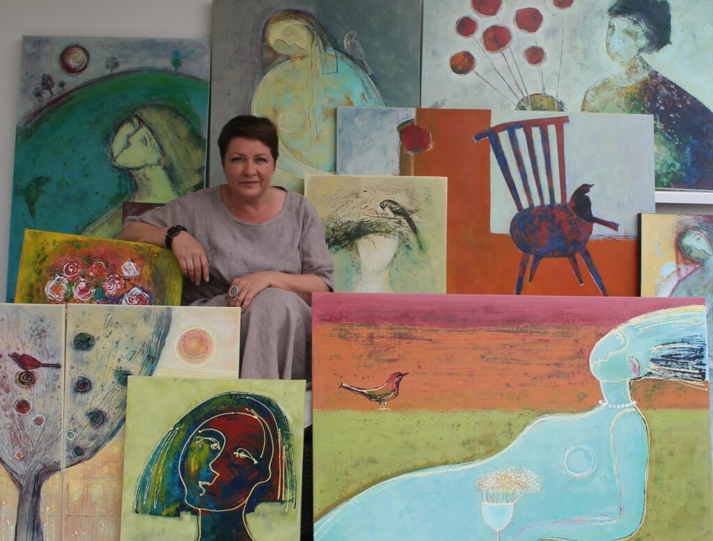 Artist Tatjana Auschew with her paintings